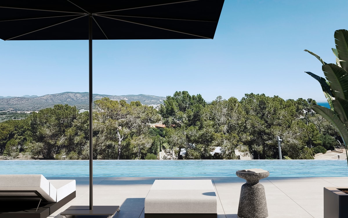 A poolside terrace with white sun loungers, a black parasol, and a clear view of pine trees and distant mountains.