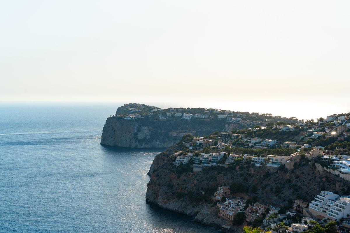 Aerial view of rocky coastline and cliffs meeting the Mediterranean sea in Port d'Andratx during daylight.
