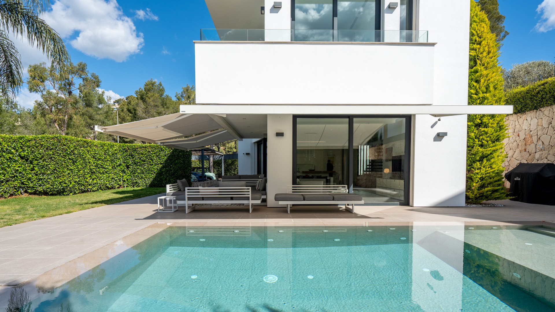 Exterior view of the villa featuring a saltwater infinity pool, covered terrace, and direct access to the living area.