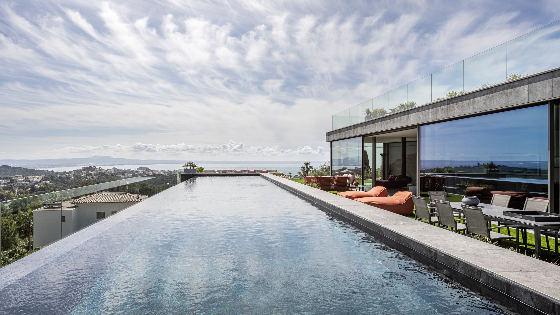 Panoramic view of a sixteen-metre infinity-edge pool overlooking the Bay of Palma, adjacent to a modern terrace.