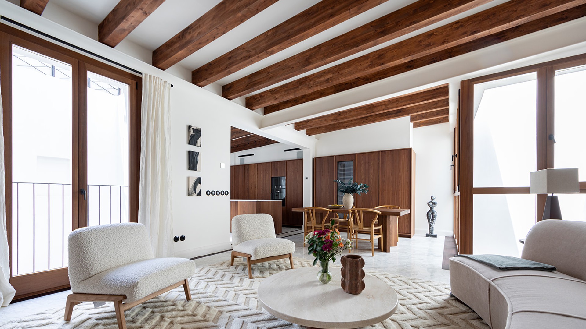 Original Mallorquín floor tiles, exposed beams and double balconies open the lower level to the rhythm of the street.