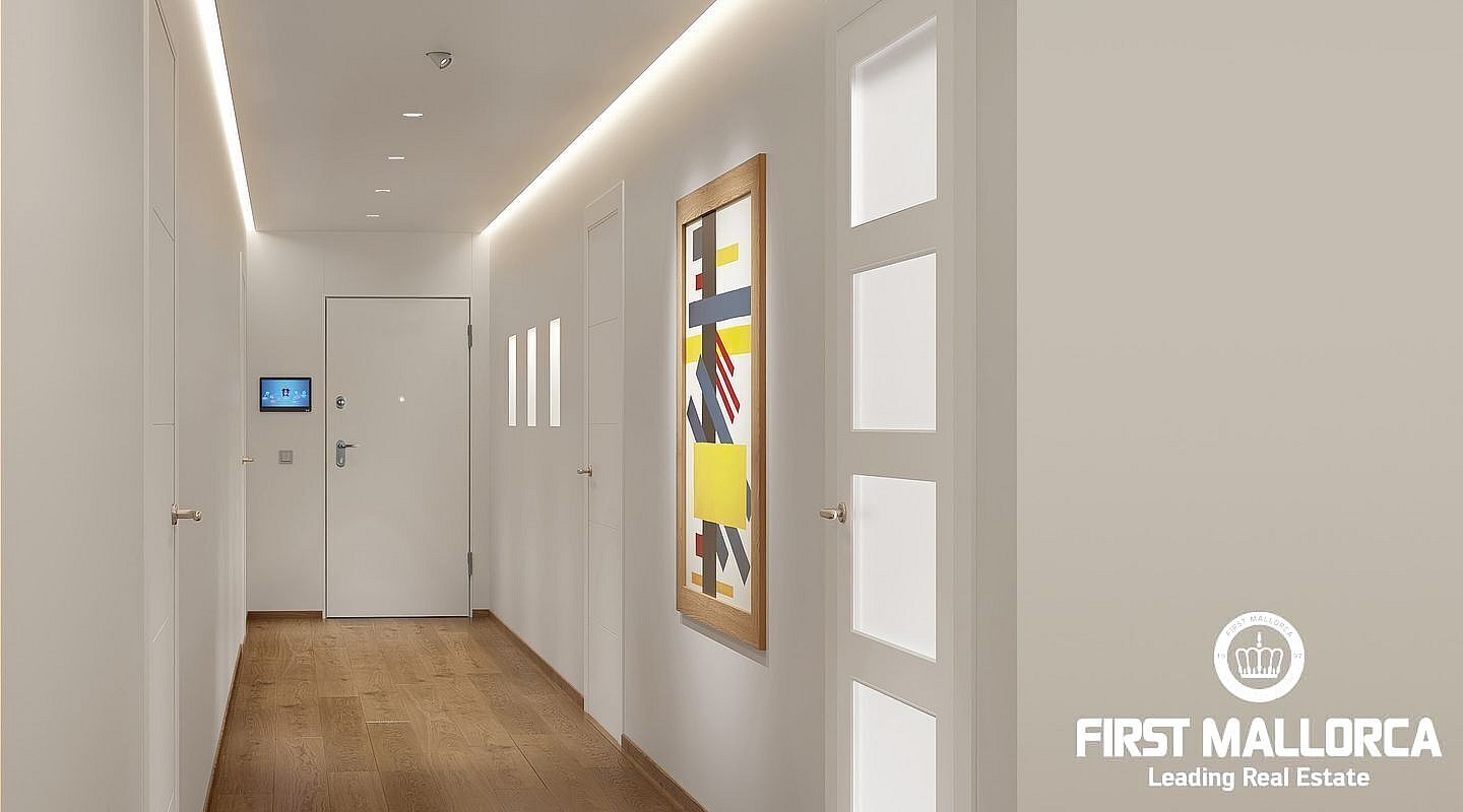 A wide interior hallway with white walls, light oak flooring, and recessed ceiling lighting leading to an entrance door.