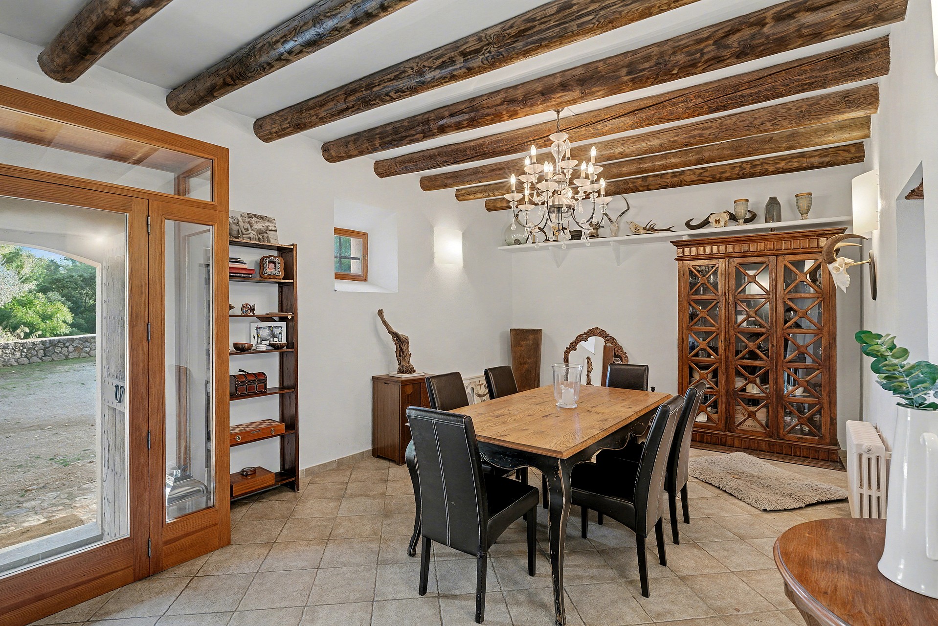 Rustic dining room with exposed wooden ceiling beams and terracotta floor tiles