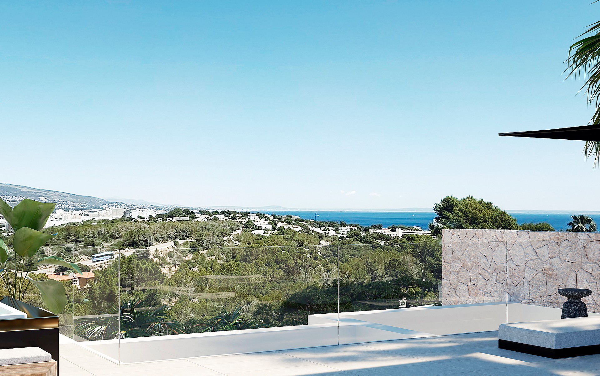 A wide terrace overlooking the Mediterranean sea with a stone retaining wall and glass railing in bright daylight.