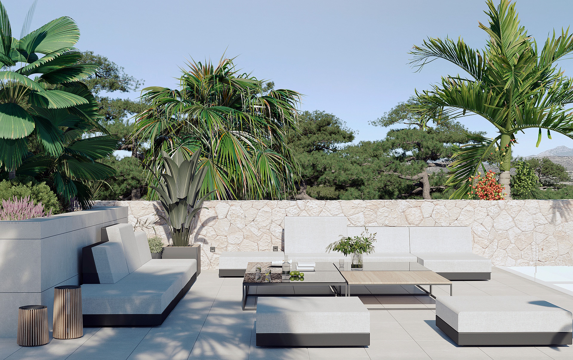 A contemporary outdoor terrace featuring low-profile modular white sofa seating and wooden coffee tables against a natural stone wall.