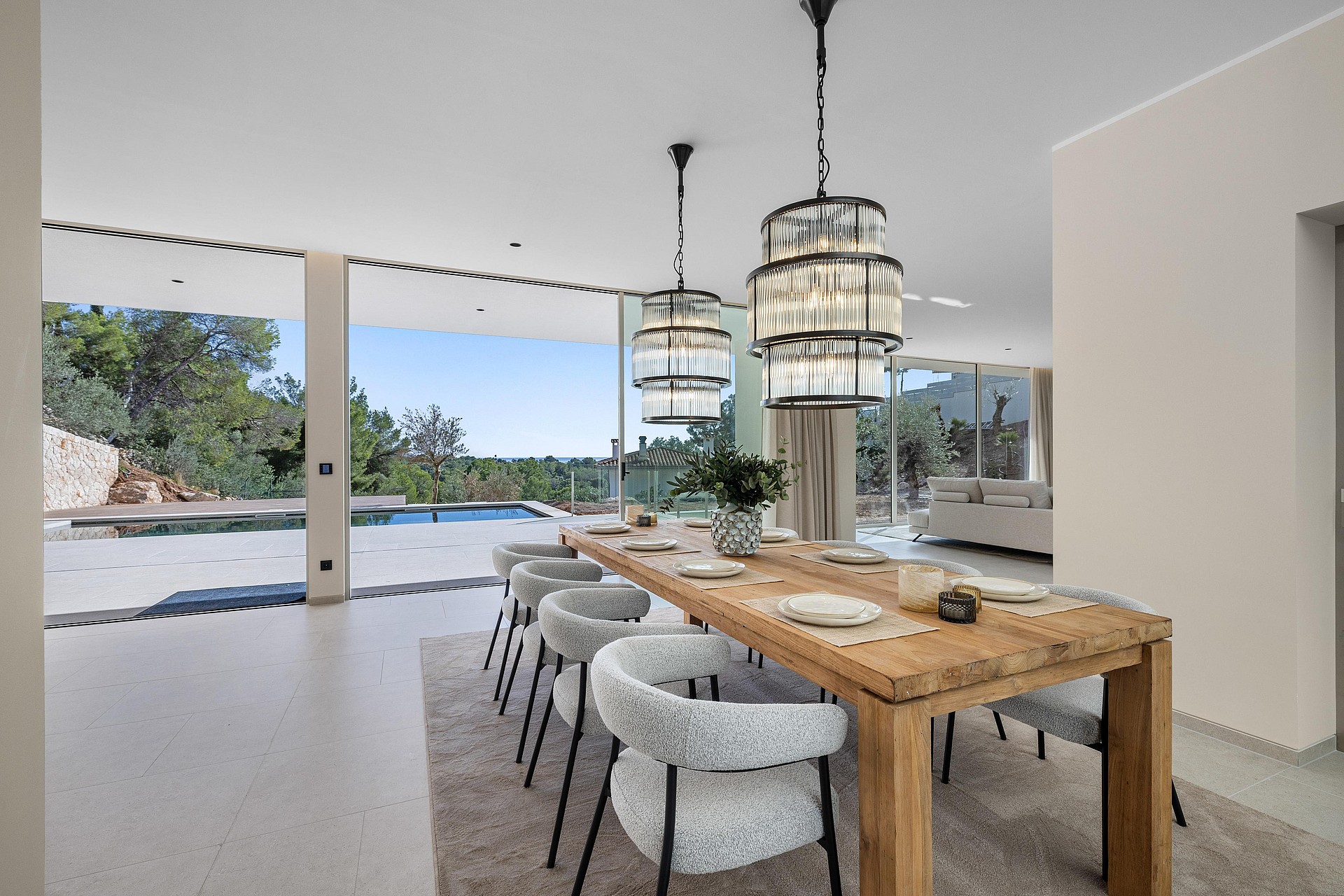 Dining room with statement pendants and retractable glass wall to the pool terrace