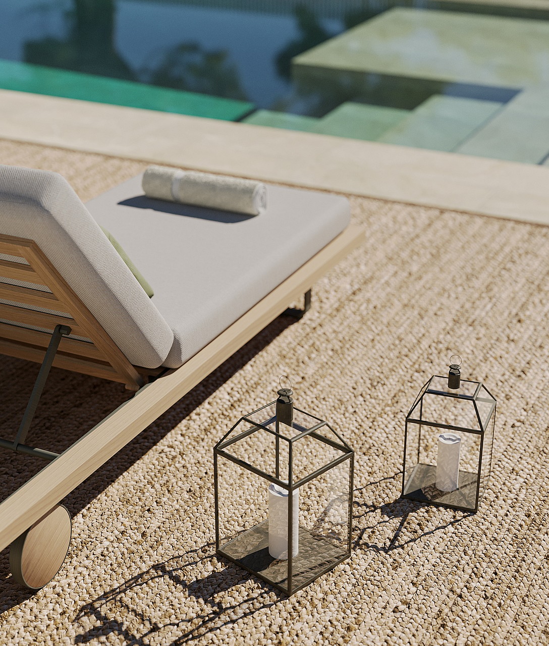 Close-up of a wooden sun lounger with cream cushions beside a pool, with two decorative metal lanterns on a gravel terrace.