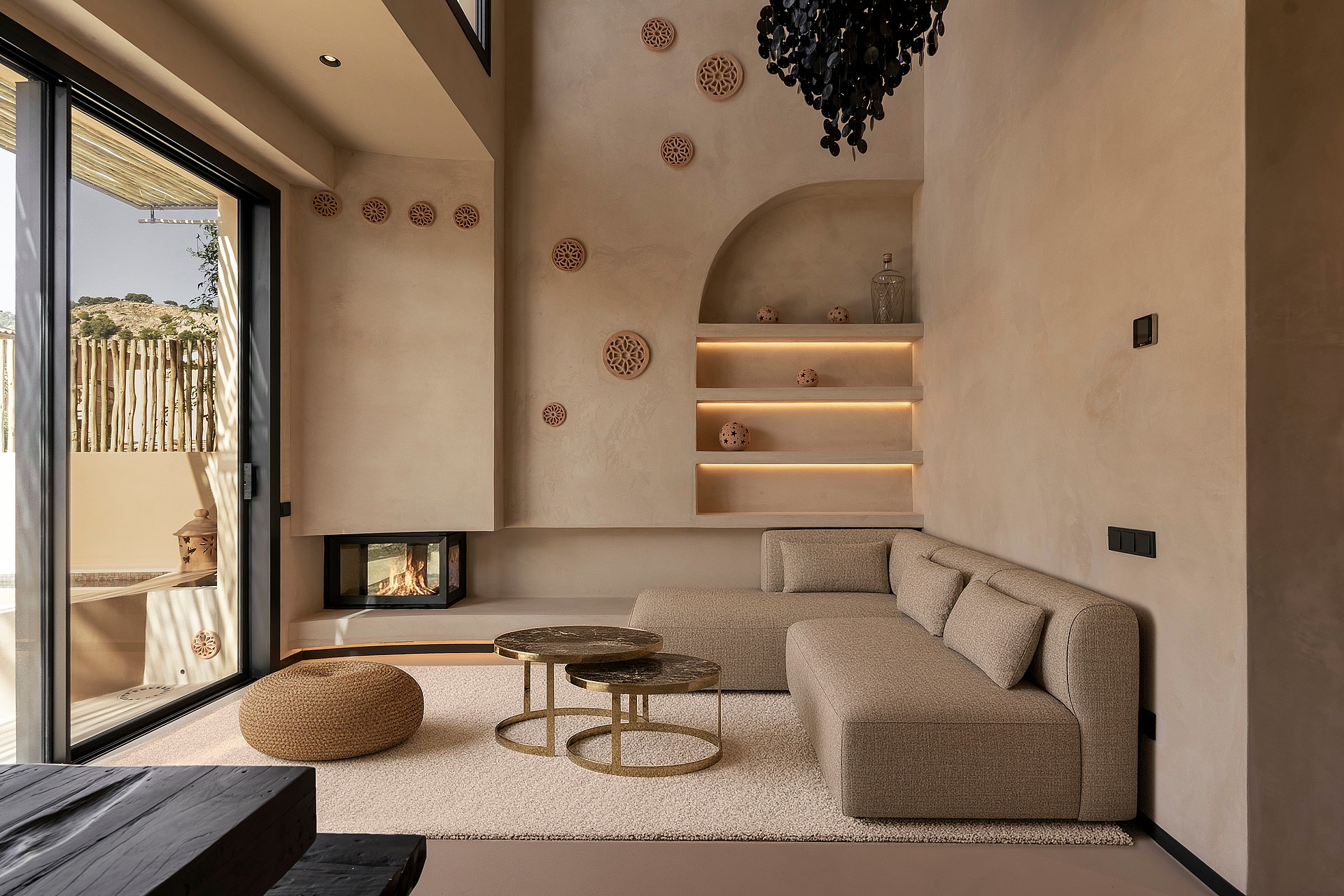 Modern living room with a textured plaster accent wall, integrated fireplace, arched shelving, and minimalist fabric sofa.