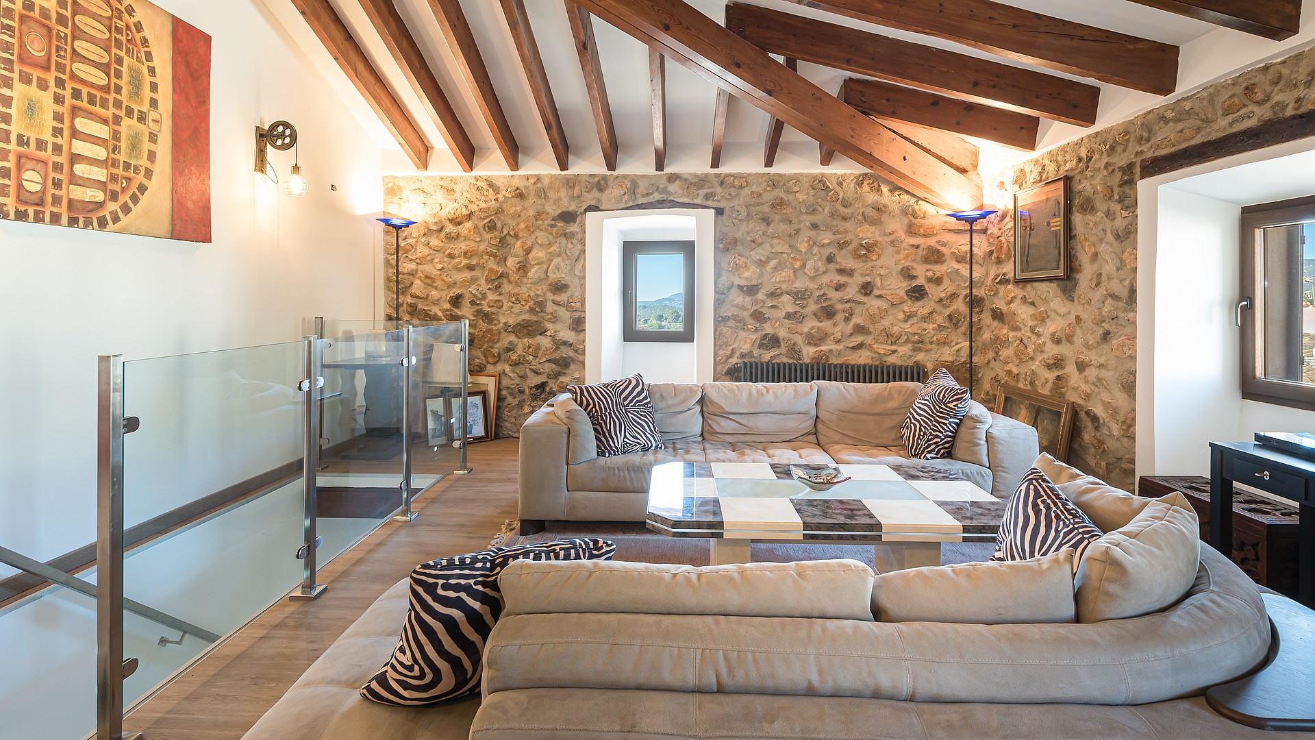 Living room with vaulted wood-beamed ceiling, stone feature wall and sectional sofa