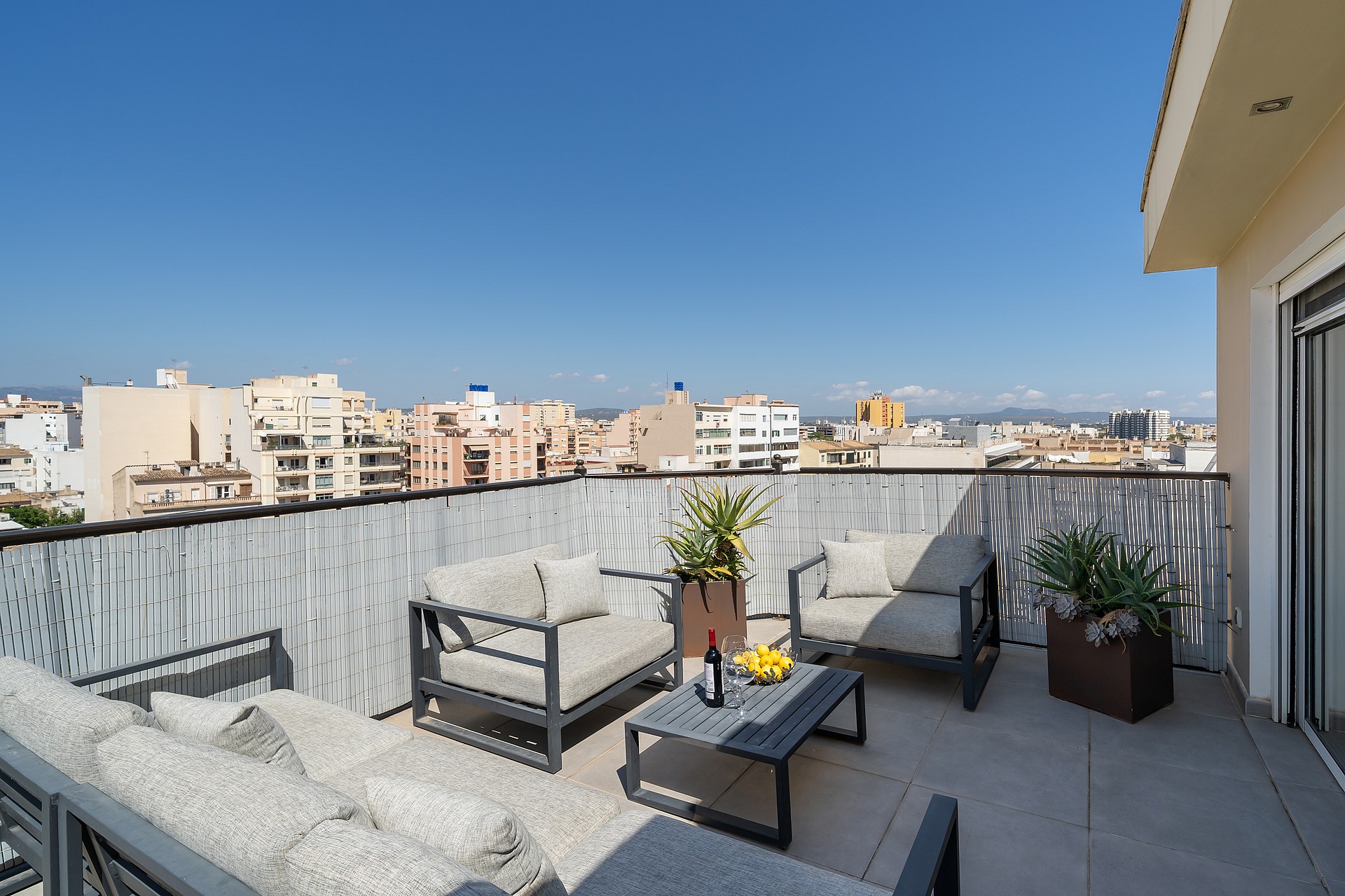 Rooftop terrace featuring outdoor sofas and a coffee table with expansive views over the Old Town city skyline.