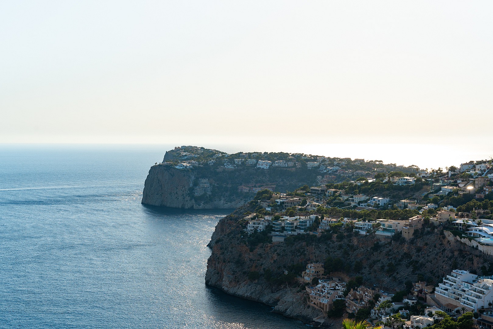 Aerial view of rocky coastline and cliffs meeting the Mediterranean sea in Port d'Andratx during daylight.