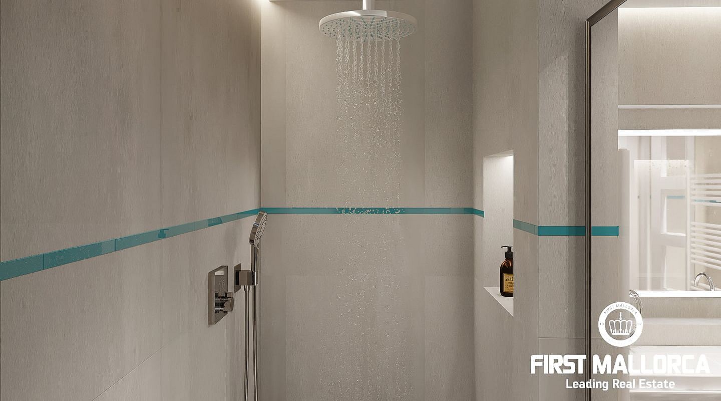 Close-up of a walk-in shower with light grey stone walls, a rainfall shower head, and a teal decorative tile accent strip.