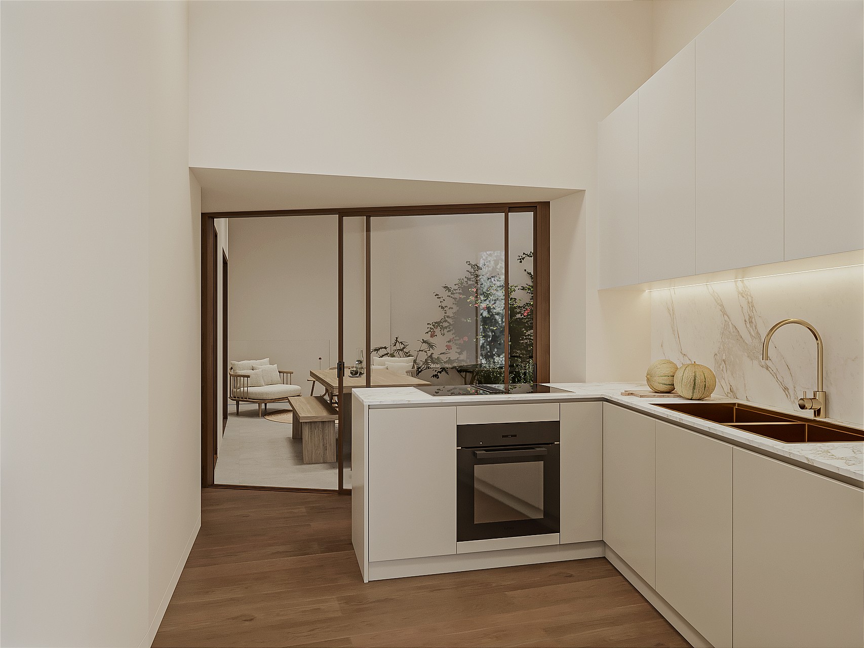 Compact kitchen with pale handleless cabinetry, marble splashback, brass tap, induction hob and integrated oven, glazed sliding partition to the living area.