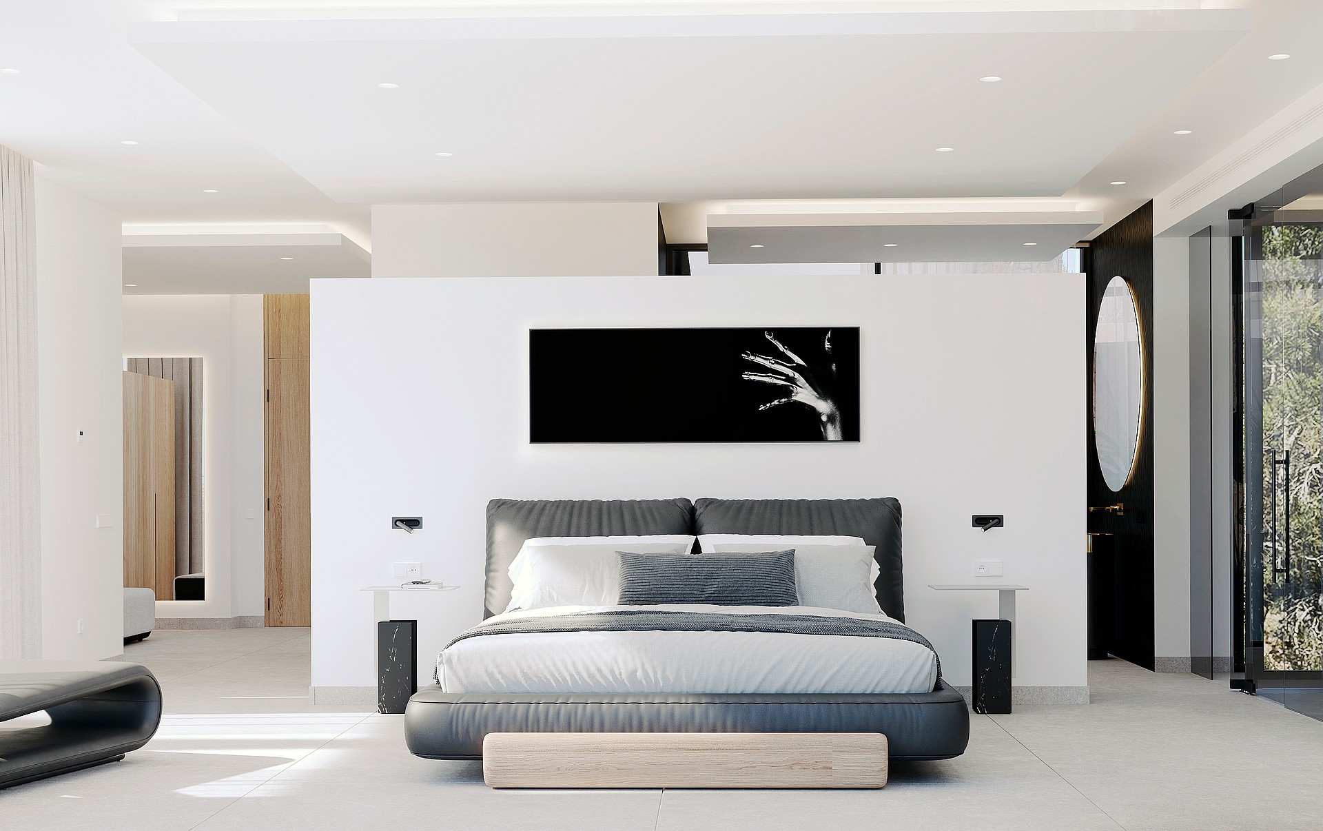 Modern bedroom with a gray upholstered bed and white walls. To the right, a circular mirror marks the en-suite entrance.