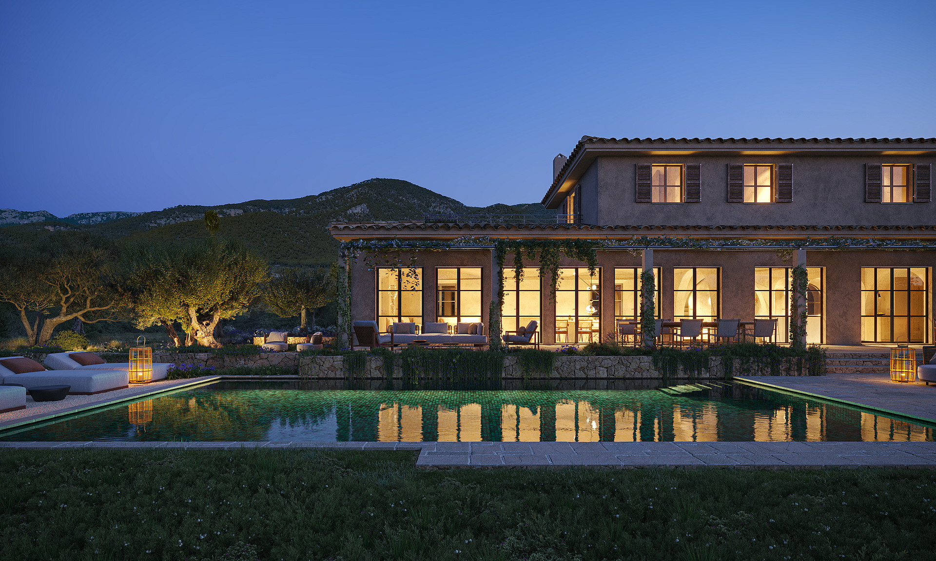 Exterior view of a stone finca at dusk, featuring a rectangular swimming pool, illuminated ground floor windows, and surrounding mountain silhouettes.