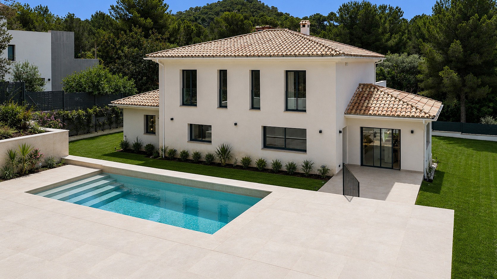 Exterior view of a white villa with clay-tiled roof, rectangular pool, and manicured lawns in Santa Ponsa.