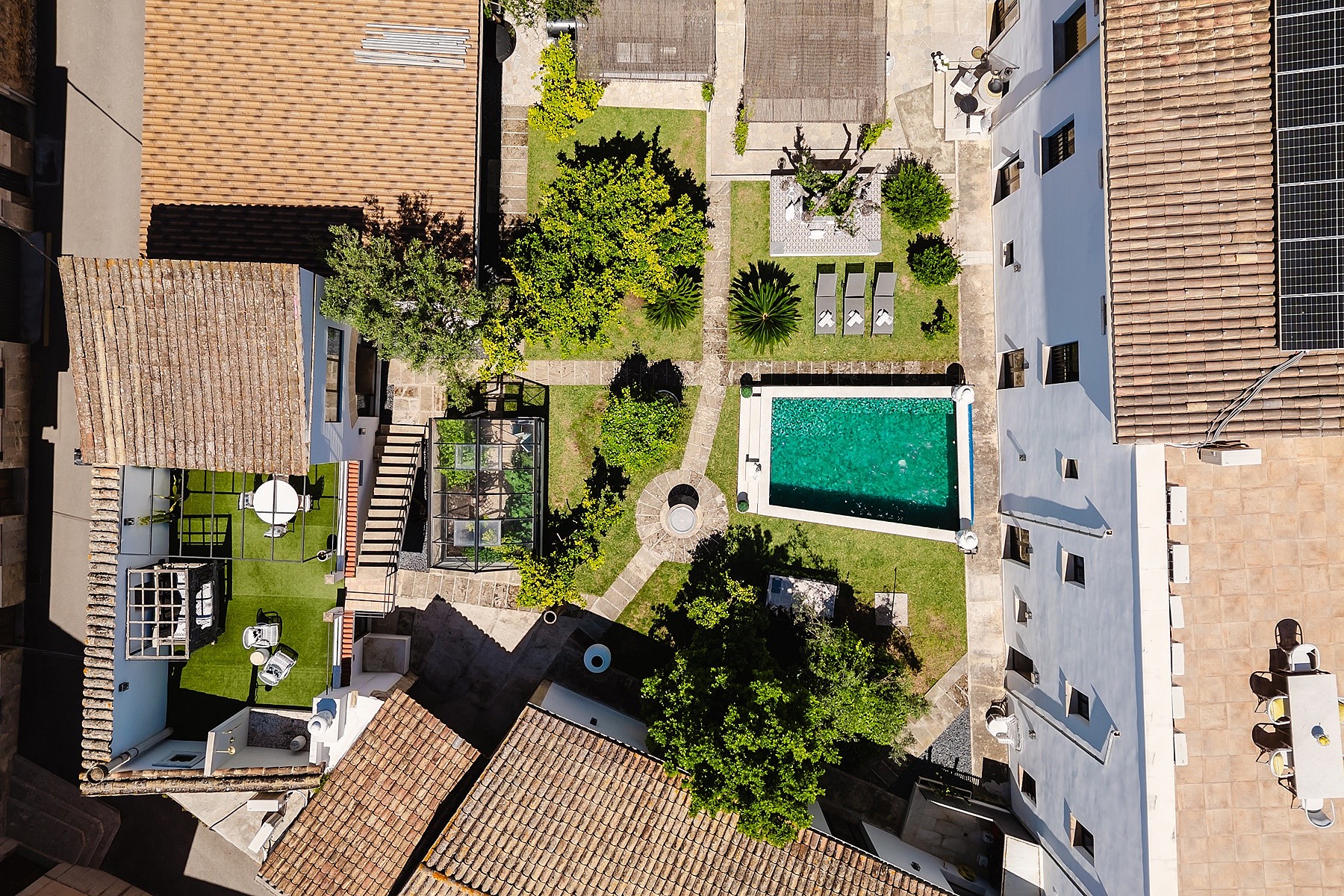 Direct overhead drone shot of a property in Sencelles, showing a rectangular swimming pool, garden areas, and white building rooftops.