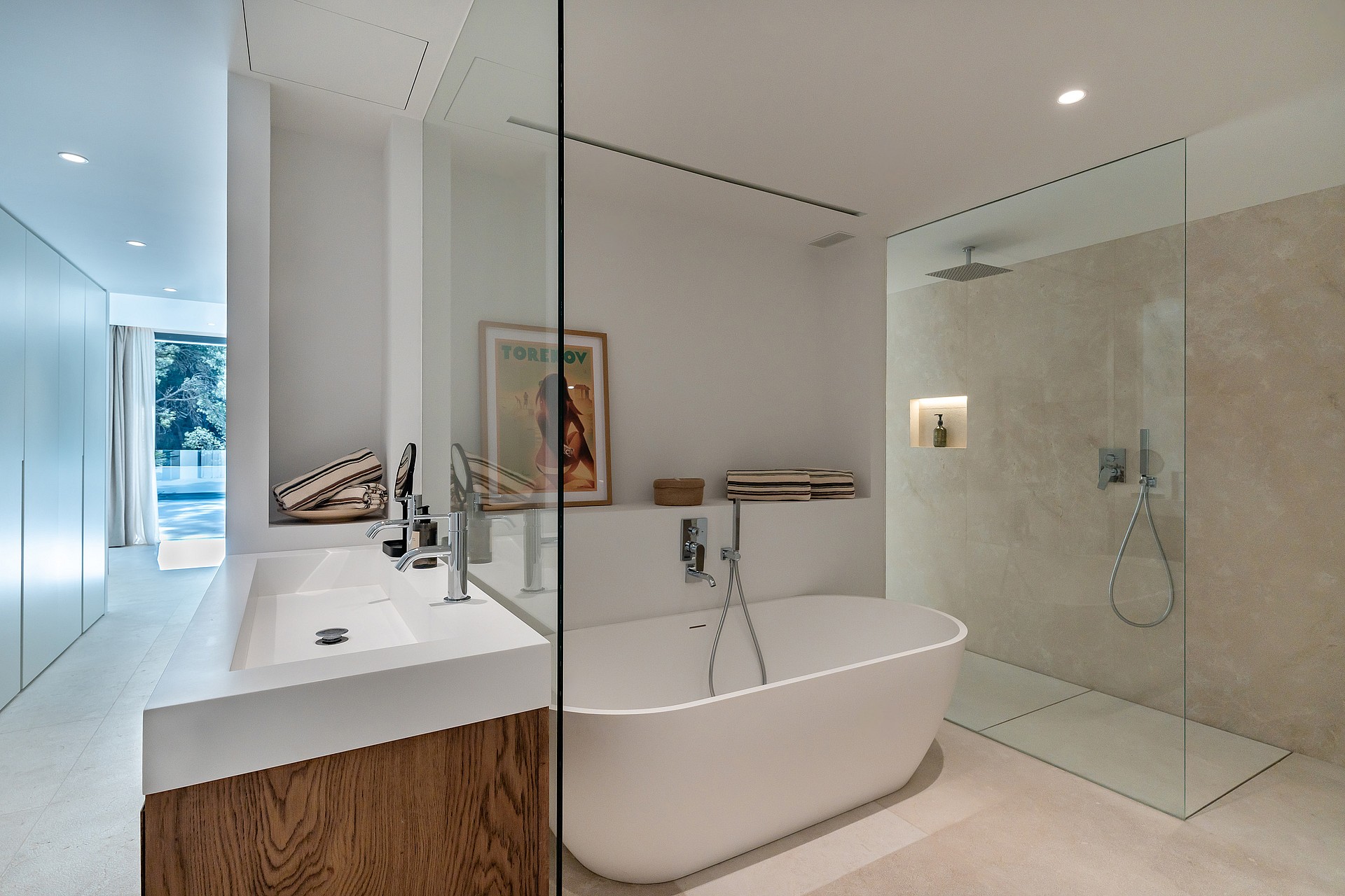 En-suite bathroom with large-format stone tiles, walk-in glass shower with rainfall head and vessel basin on timber vanity unit