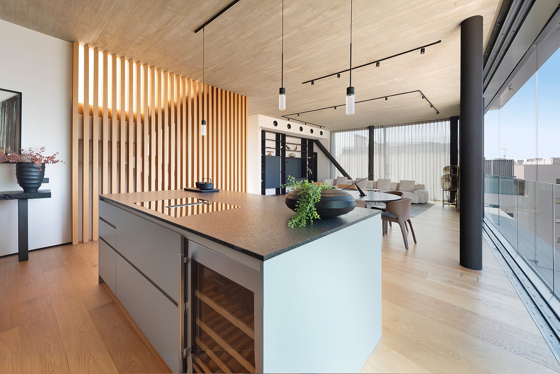 A modern kitchen island with a stone countertop and integrated wine fridge, set against a background of vertical wooden slats.