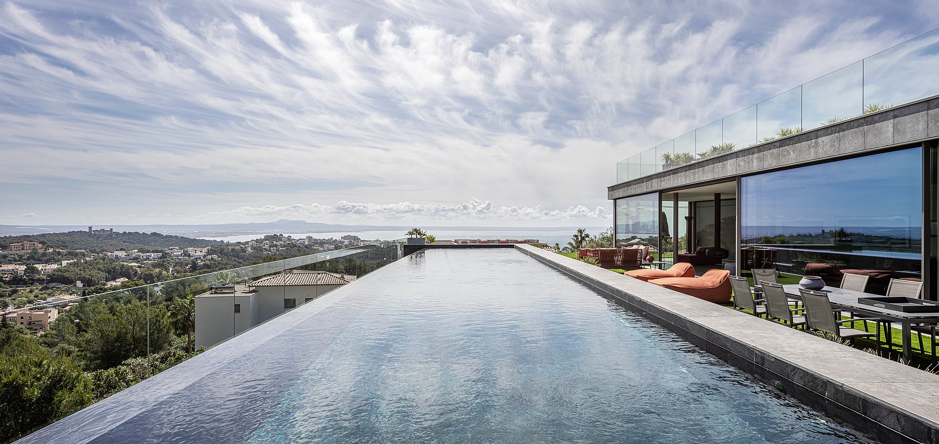 Panoramic view of a sixteen-metre infinity-edge pool overlooking the Bay of Palma, adjacent to a modern terrace.