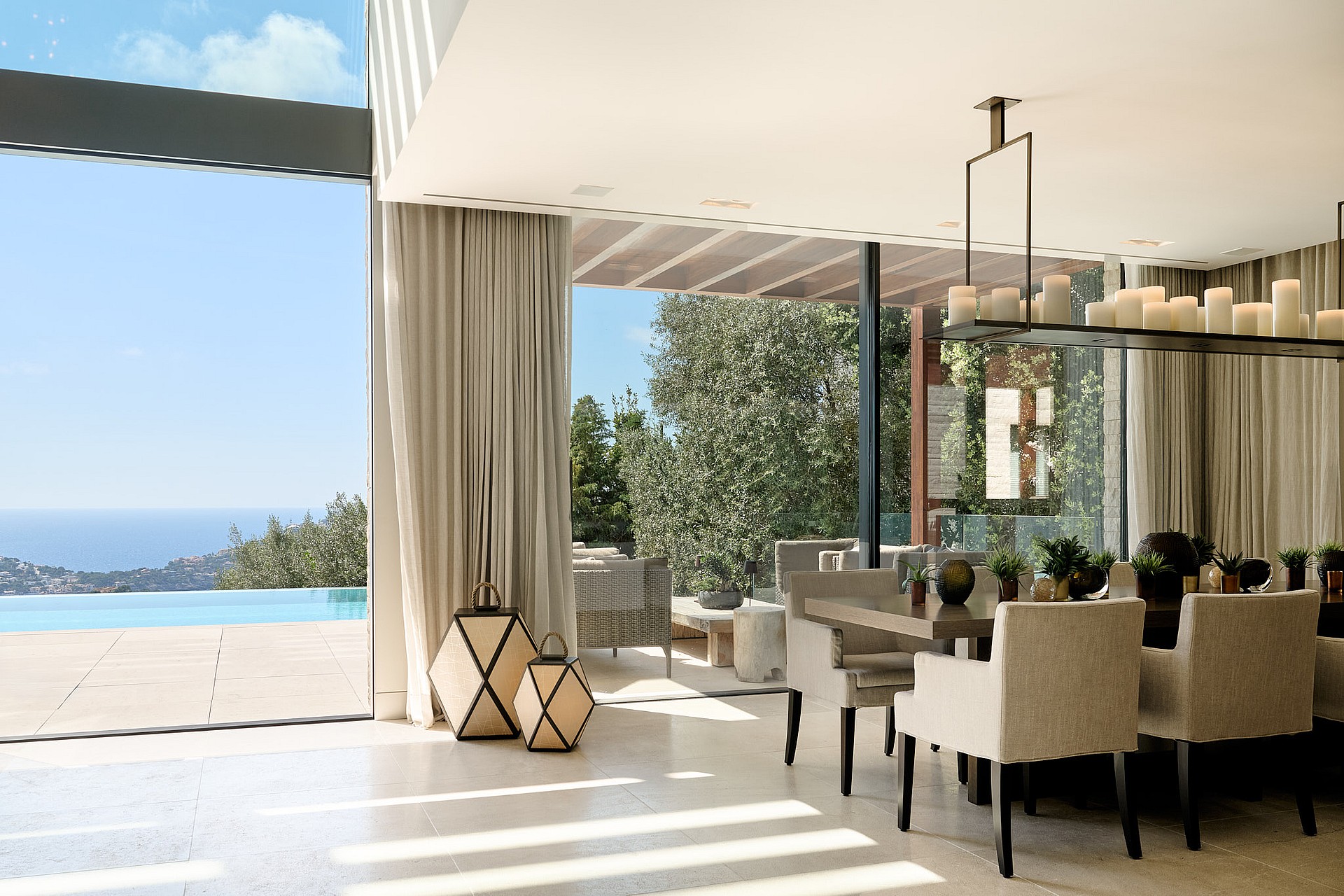 Open-plan living and dining room with natural-toned furnishings and large glazing