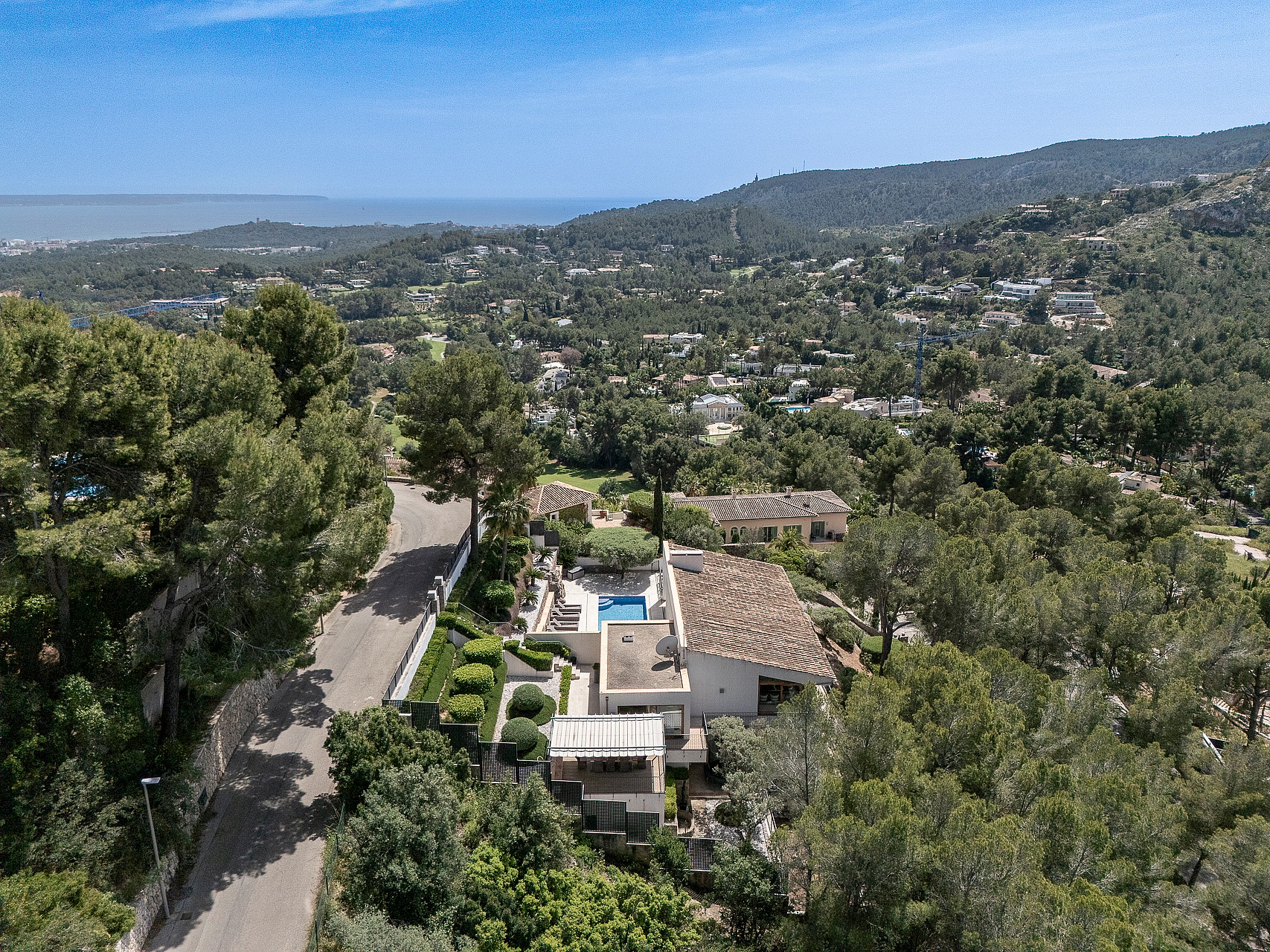 Elevated view from Son Vida villa across green pine-covered hillside toward Palma Bay and the Mediterranean
