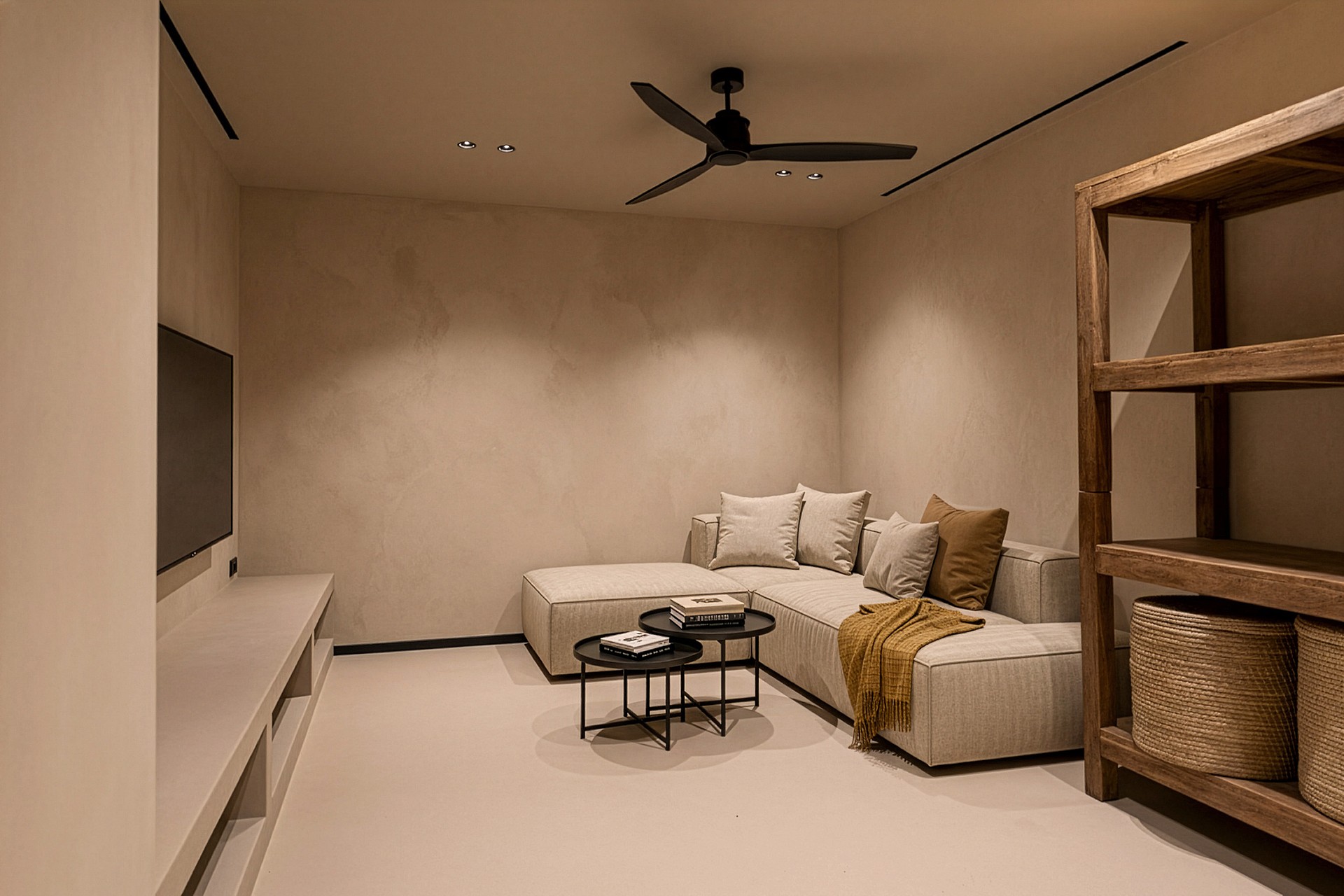 A minimalist living room with a beige sectional sofa, a low white console, and a wooden storage unit under a ceiling fan.