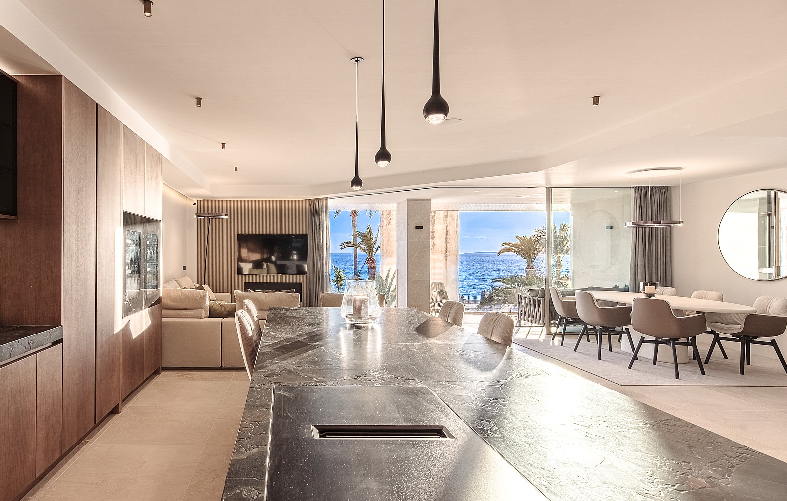 Dining area with marble countertops, designer pendant fixtures and seamless access to the waterfront loggia
