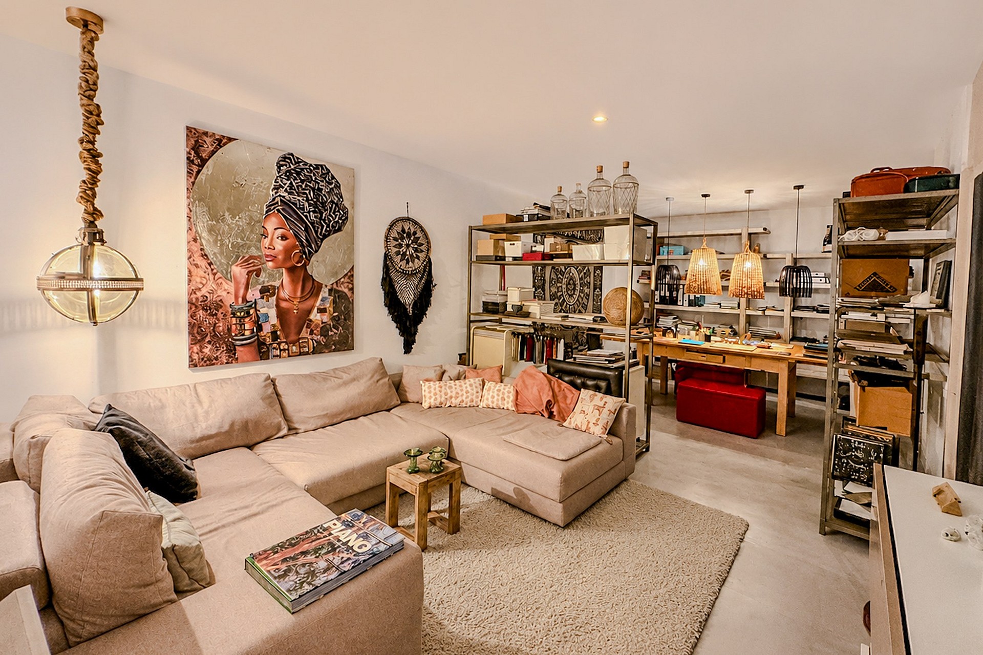 A spacious living room featuring a large beige sectional sofa, decorative wall art, and an adjacent open-plan dining space.