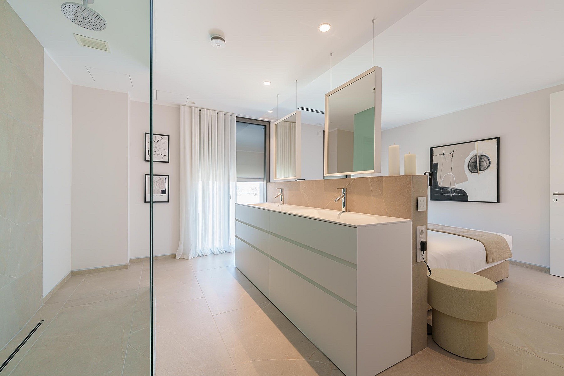 Dormitorio moderno con partición central, espejos dobles, ducha de cristal y cama minimalista.