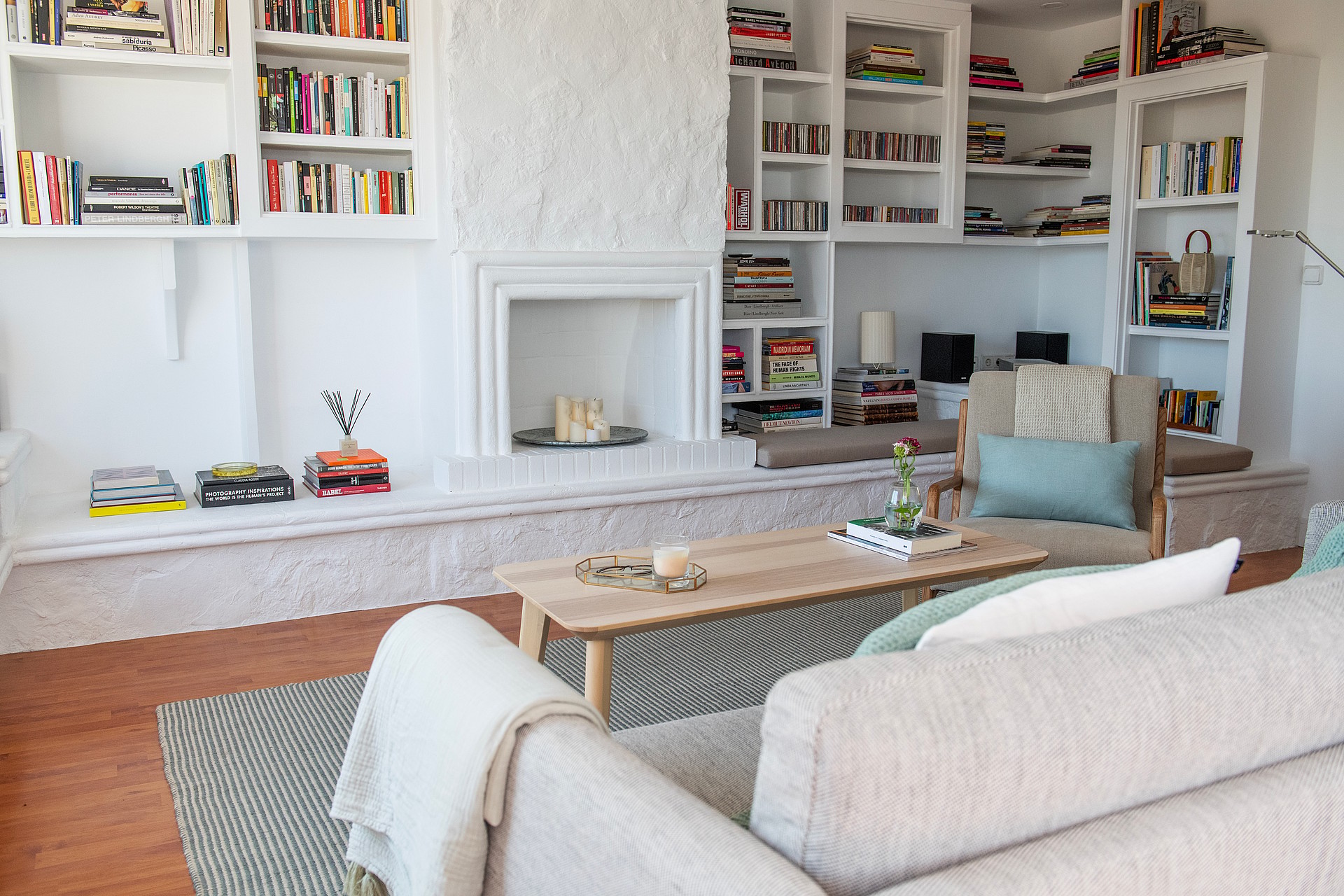 Living room interior featuring white built-in bookshelves surrounding a central fireplace and a light wood coffee table.