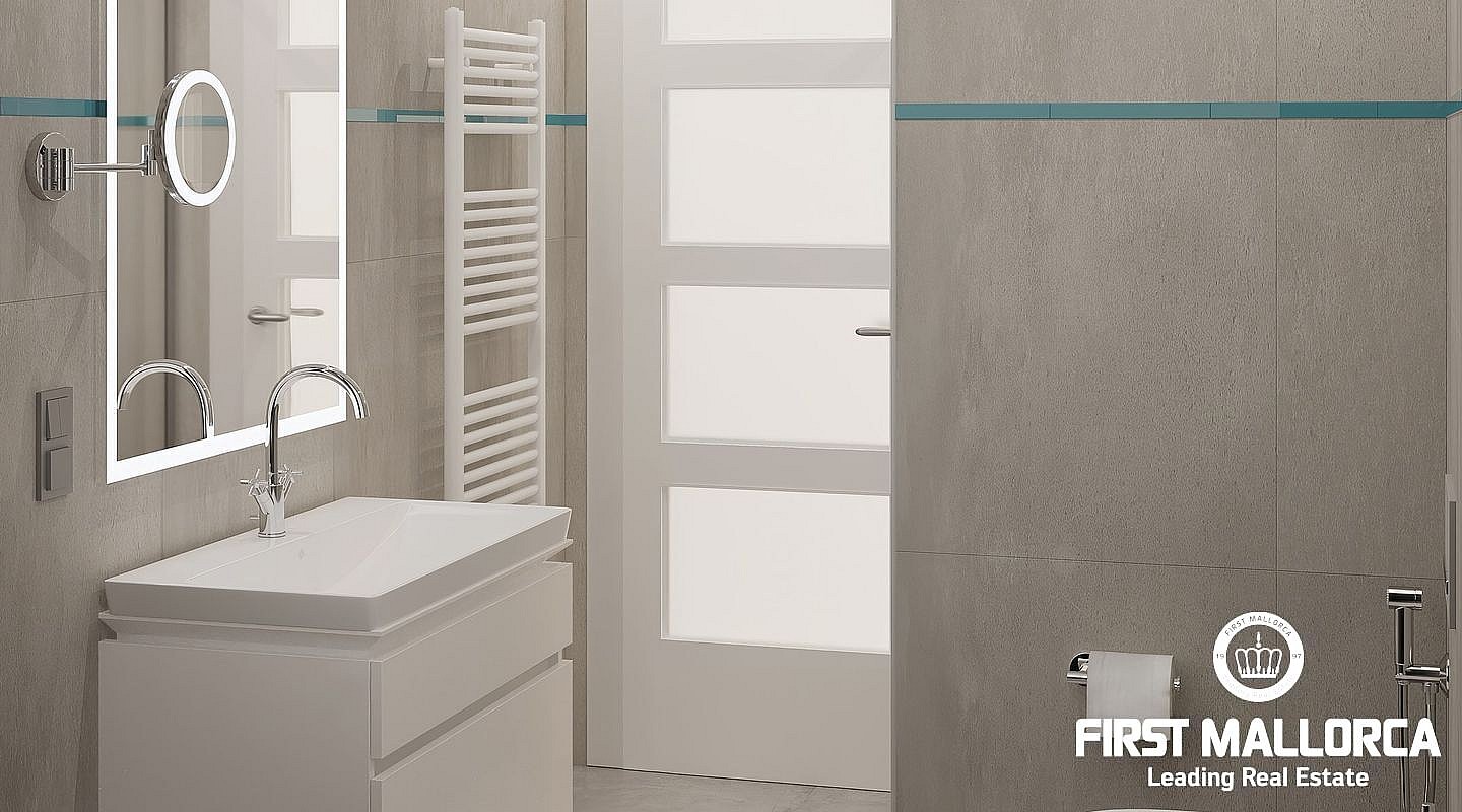 A modern bathroom featuring grey tiled walls, a white floating vanity, a backlit mirror, and a wall-mounted towel rail.