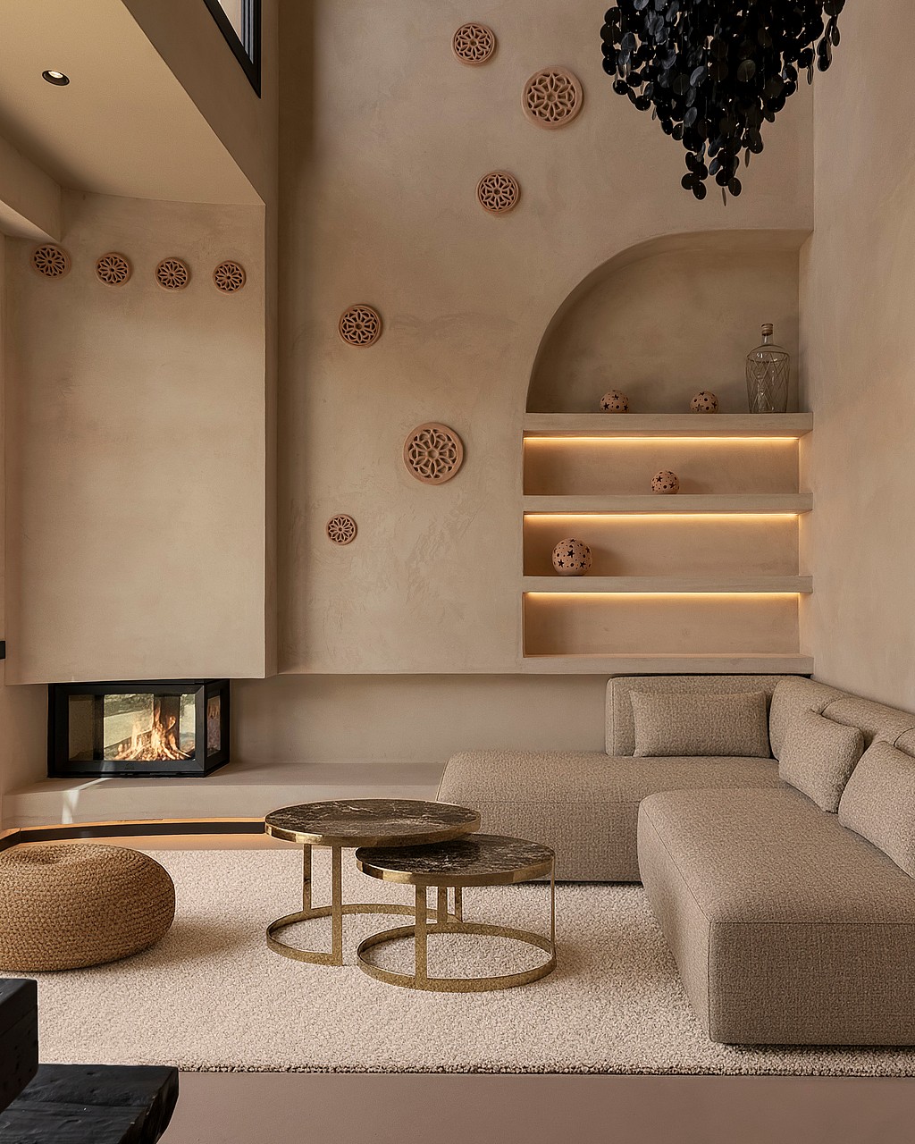 A modern living room with beige textured walls, a recessed fireplace, a modular sofa, and integrated shelving with warm lighting.