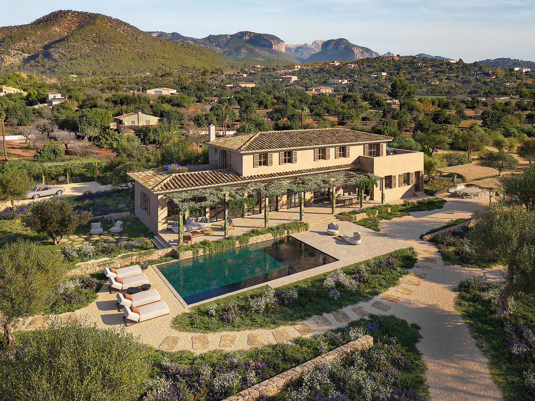 Aerial view of a traditional stone finca with a swimming pool, pergola-covered terrace, and surrounding Mediterranean gardens.