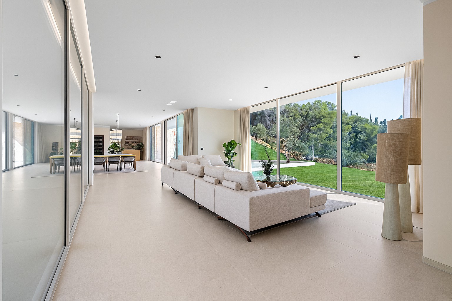 Spacious living area with oversized sectional sofa and full-height sliding glass to pool terrace
