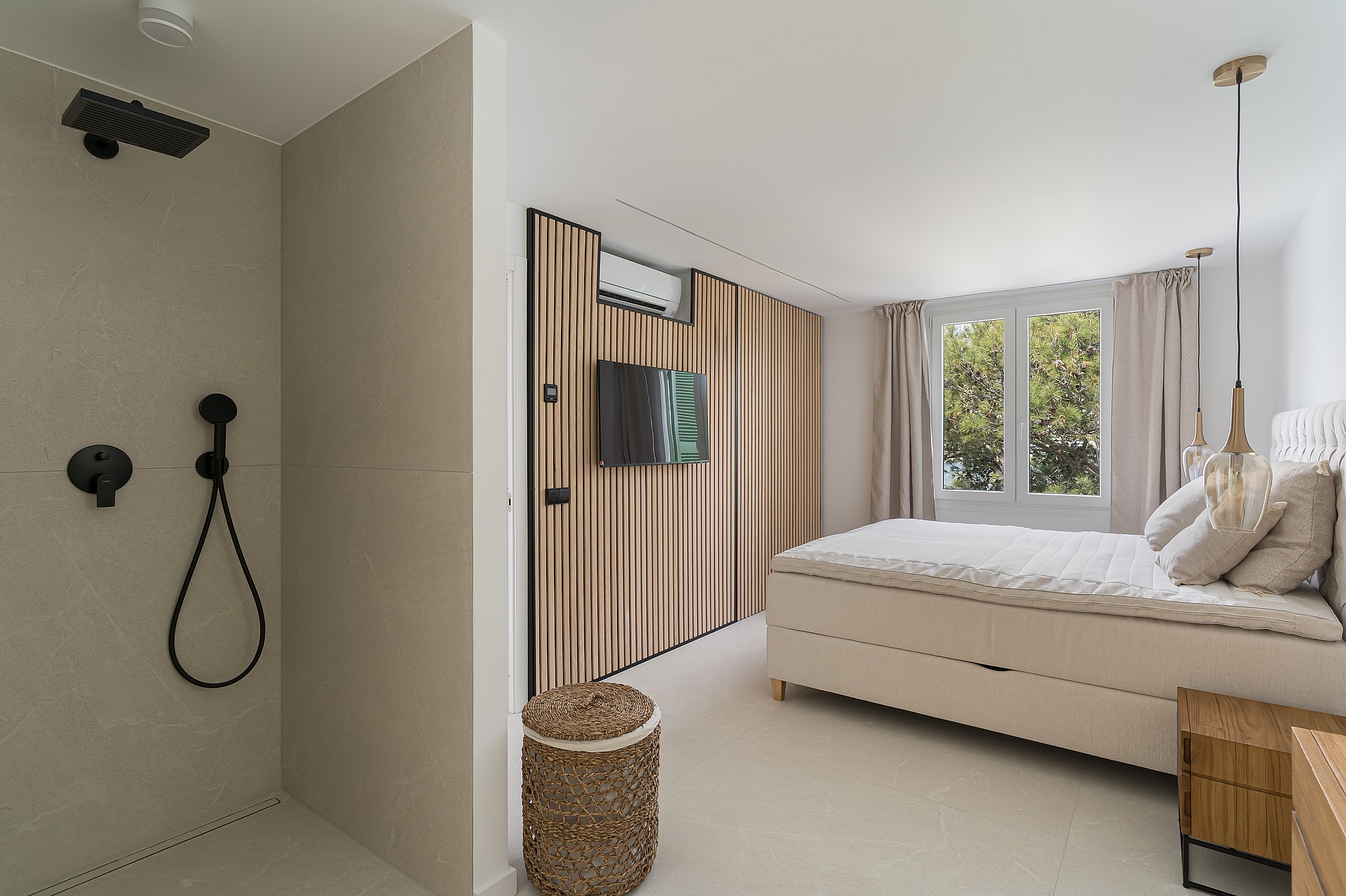 Contemporary bedroom featuring a vertical wood slat wall, upholstered bed, glass pendant lights, and garden views.