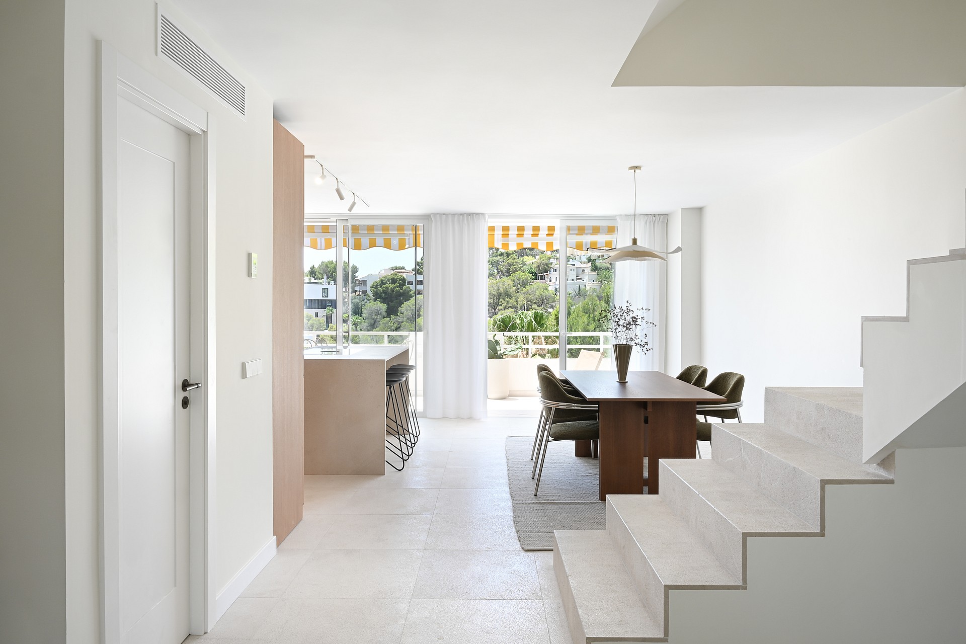 Living room with linen sofa, walnut coffee table, and floor-to-ceiling glazing framing seaview terrace