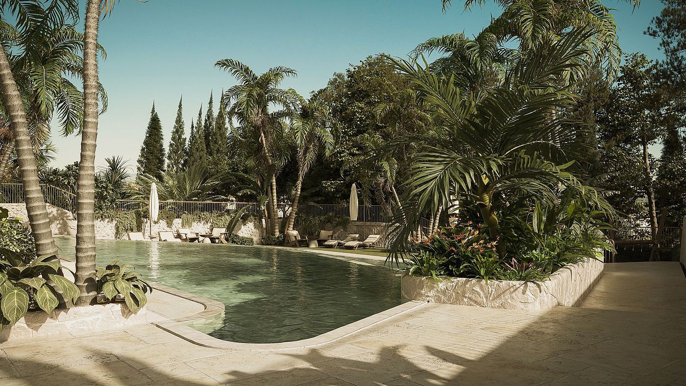 Outdoor swimming pool surrounded by palm trees and lush vegetation with stone paved terrace area under natural daylight.