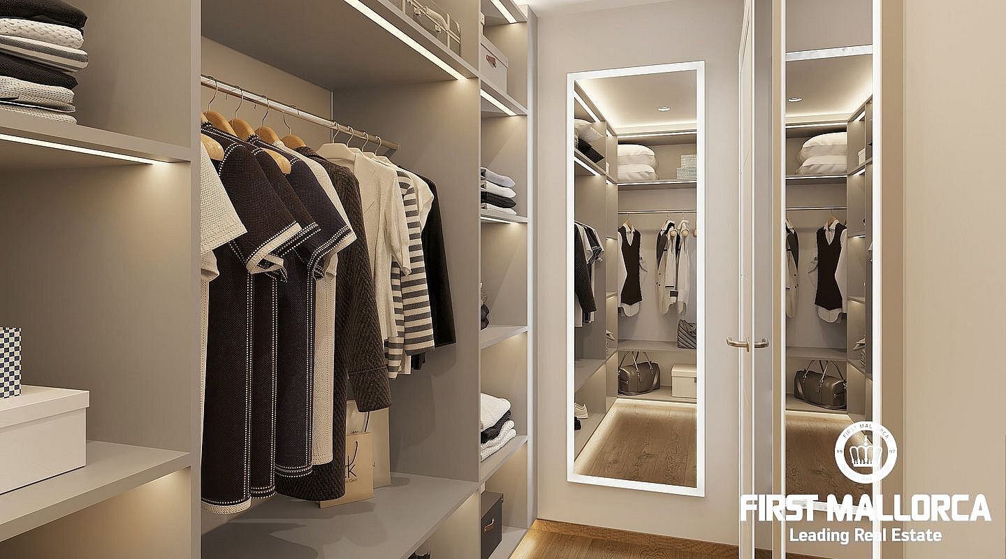 A modern walk-in wardrobe featuring hanging rails, open shelving, and a full-length mirror with LED perimeter lighting.
