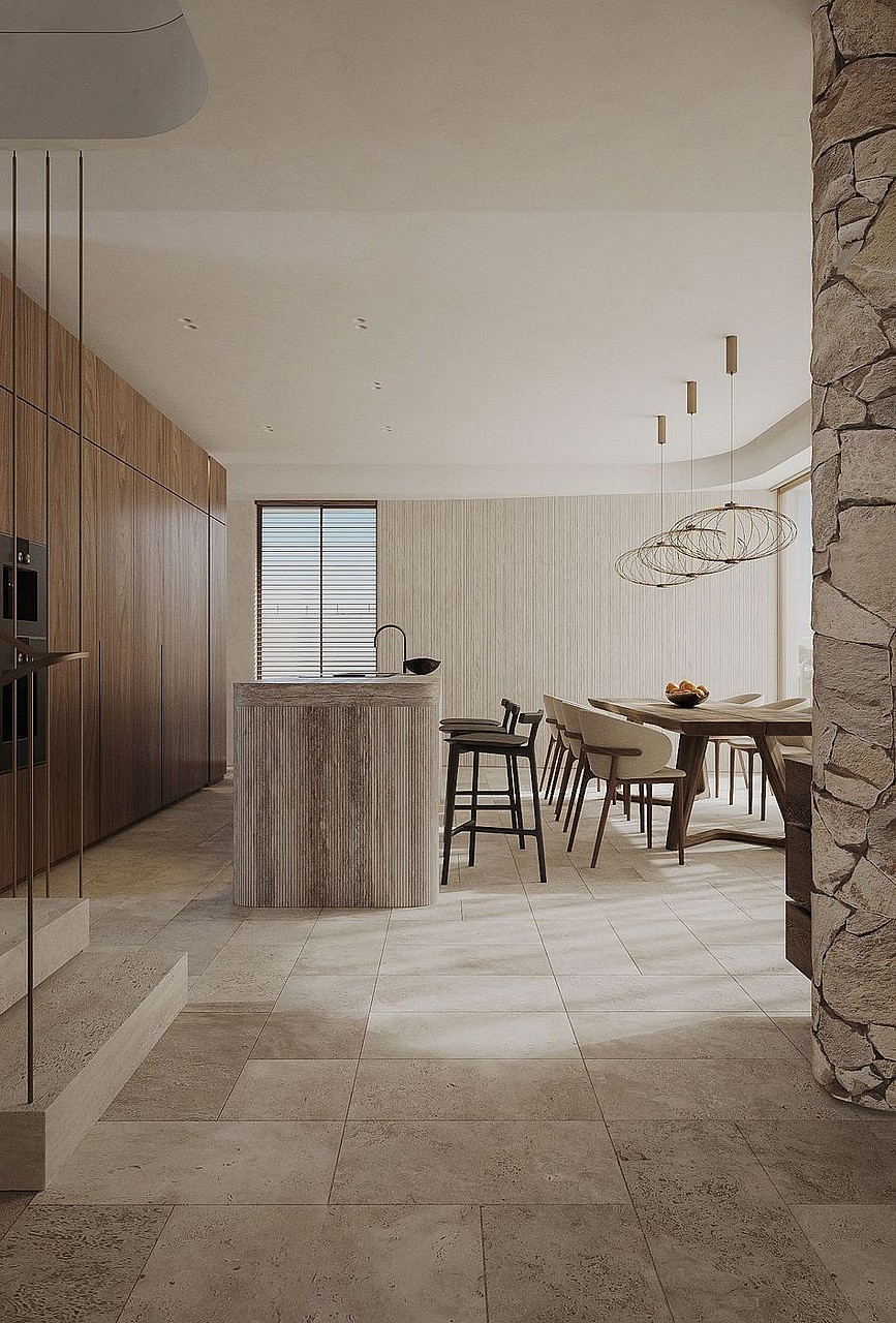 Contemporary kitchen featuring a fluted stone island, wooden cabinetry, and stone tiled flooring under warm recessed lighting.