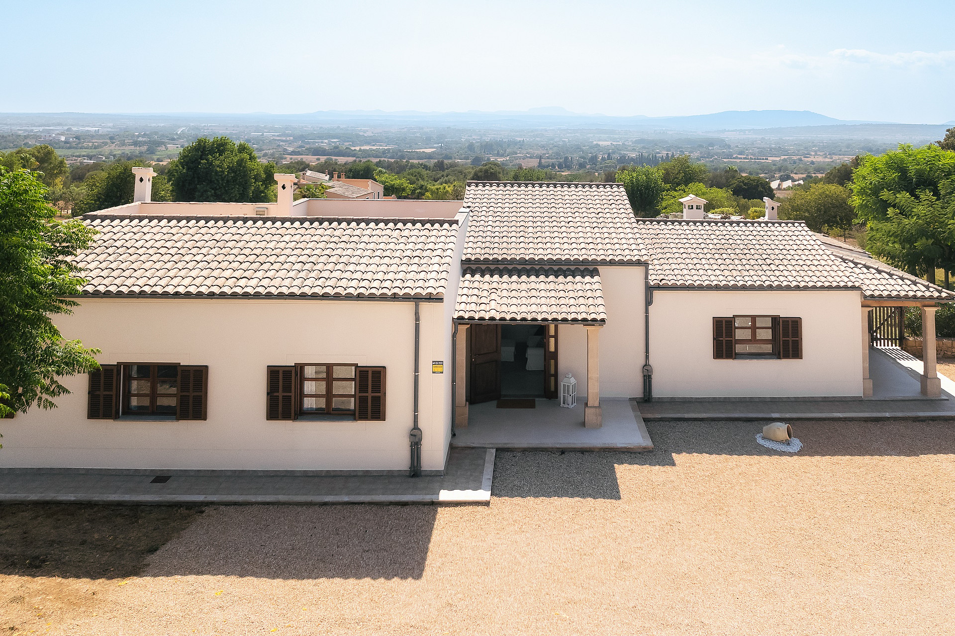 Vista exterior de una finca tradicional de una planta con muros encalados, tejado de teja y contraventanas de madera.