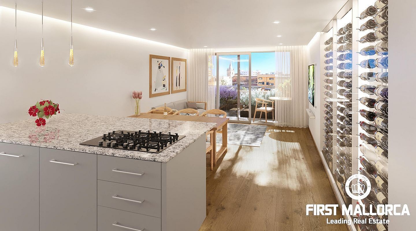 Modern open-plan kitchen featuring a grey island with granite countertop, floor-to-ceiling glass wine cellar, and light wood flooring.