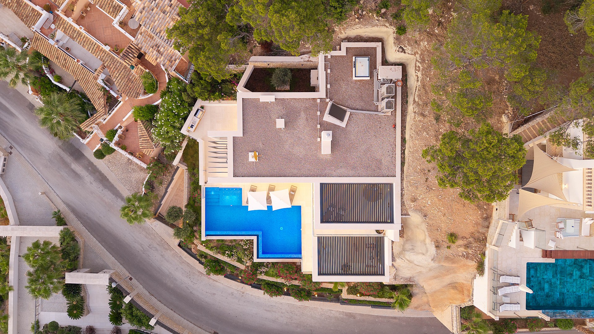 Top-down aerial view of a villa in Port d'Andratx showing a blue rectangular swimming pool, a flat roof, and surrounding vegetation.
