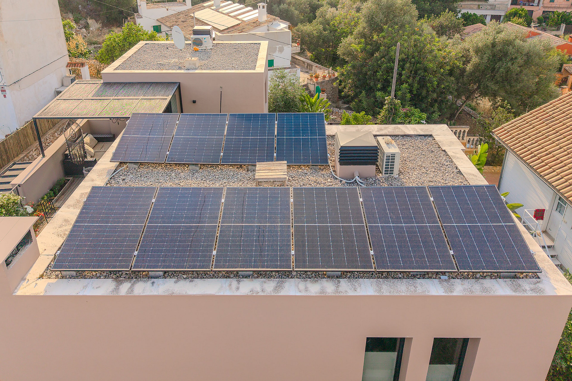 Aerial view of a flat rooftop featuring a modern solar panel array in a residential setting in Genova.
