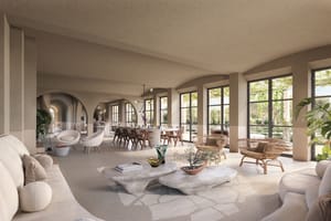 Spacious living and dining room with arched walls, light stone floors, neutral upholstered sofas, and large glass doors.