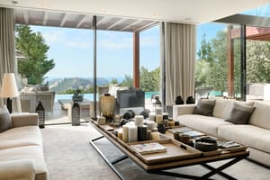 Open-plan living and dining room with natural-toned furnishings and large glazing