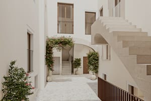 Interior courtyard featuring Marés stone, stone stairs, and greenery within a restored historic building.