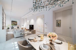 Bright open-plan living area featuring a modern dining set with upholstered chairs and a sofa area with neutral textiles.