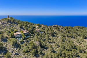 Aerial view of George Sand Villa nestled in the pine-covered hills of Valldemossa overlooking the Mediterranean Sea.