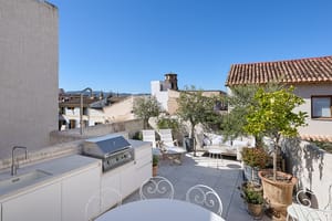 Sunny terrace featuring an outdoor kitchen, barbecue, lounge area, and views of the Old Town rooftops.
